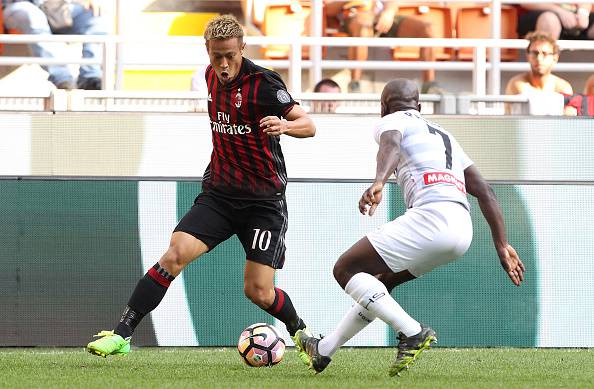 MILAN, ITALY - SEPTEMBER 11:  Keisuke Honda of AC Milan is challenged by Pablo Armero of Udinese Calcio during the Serie A match between AC Milan and Udinese Calcio at Stadio Giuseppe Meazza on September 11, 2016 in Milan, Italy.  (Photo by Marco Luzzani/Getty Images)